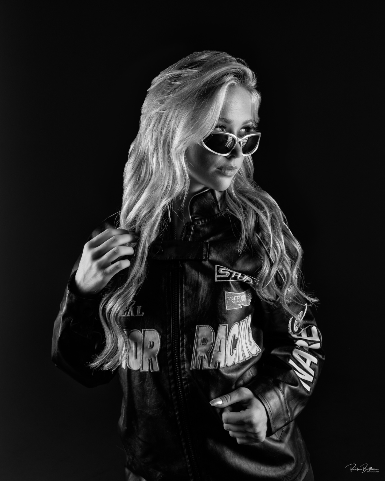 Black and white portrait of Maggie wearing sunglasses and a jacket